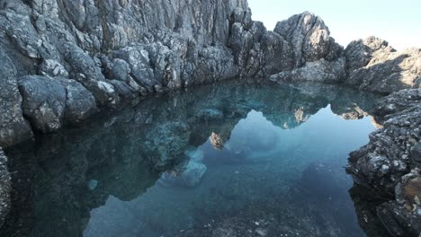 Clear-water-surrounded-by-tall-rock