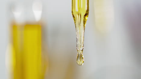 A-yellow-liquid-flowing-from-a-pipette,-close-shot
