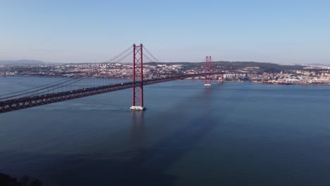High-Stationary-Drone-Shot-over-Bay-harbour-and-red-suspension-Bridge-in-Portugal-Lisbon