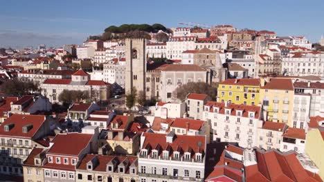 Drone-rises-straight-up-over-Old-Town-Lisbon-Portugal-Europe-on-a-bright-sunny-day
