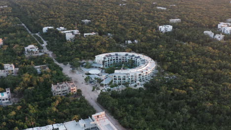 Counter-clockwise-orbiting-shot-of-white-building-in-Tulum-Mexico-during-sunset