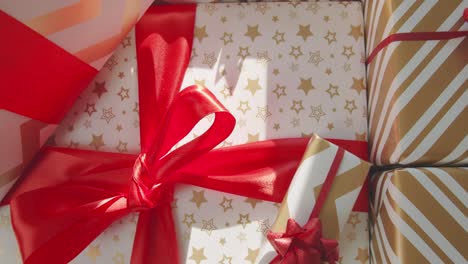 Top-down-over-wrapped-presents-with-big-red-bows-with-gold-and-white-paper