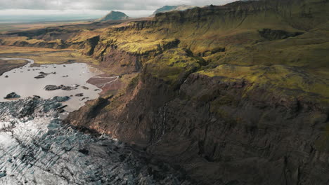 Aerial-rise-over-dramatic,-rugged-Iceland-mountain-landscape,-melting-glacier