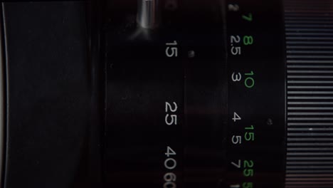 Close-up,-black-camera-lens-aperture-focus-ring-rotating,-adjusting