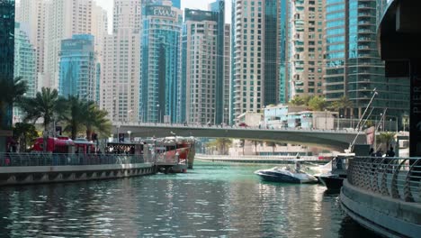 Brücke-über-Den-Wasserkanal-Am-Hafen-Von-Dubai-Marina-Mit-Möwen-Und-Türmen