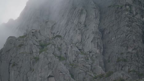Close-up-of-a-huge-granite-wall-from-the-botom-to-the-top-on-a-cloudy-day