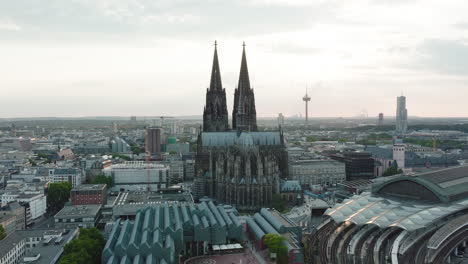 Drone-moves-in-slow-motion-epic-towards-the-Cologne-Cathedral,-it-comes-very-close-to-the-Cologne-Cathedral-and-you-can-see-the-sunbeams-shining-through-the-towers,-cinematic-intro