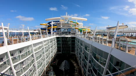 Colourful-Water-slides-and-swimming-pool-on-top-of-luxury-cruise-ship-cinematic-view|-luxury-cruise-ship-upper-deck-with-beautiful-water-park-and-pools-,-cruising,-travel