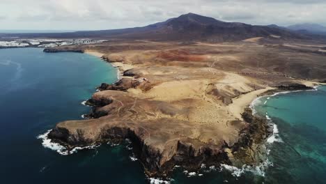 Majestic-landscape-with-mountain-in-horizon-in-Lanzarote-island,-aerial-view