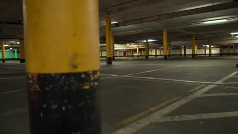Empty-underground-car-park-at-night,-no-vehicle-in-spots-in-the-parking-lot
