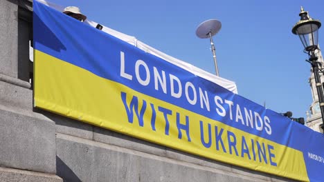 London-stands-with-Ukraine,-banner-of-solidarity-and-support-in-Trafalgar-Square-in-London-during-protest-against-war-with-Russia