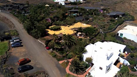 Yellow-rooftop-of-small-luxury-villa-in-Lanzarote-island,-aerial-fly-away-view