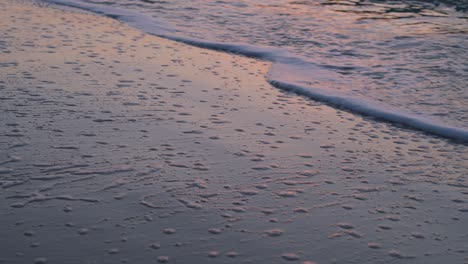 Ruhige-Meereswellen,-Die-Den-Sandstrand-Erreichen-Und-Eine-Textur-Mit-Weißem-Seeschaum-Erzeugen