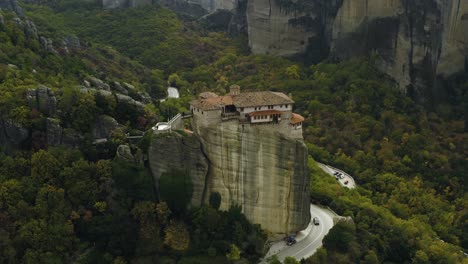 Aerial-view-around-the-Moní-Rousánou-monastery,-in-cloudy-Meteora,-Greece---high-angle,-orbit,-drone-shot