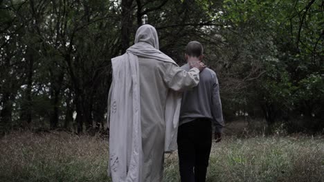Jesus-walks-through-forest-with-his-hand-on-a-young-teen-boys-back