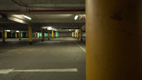 Empty-underground-car-park-at-night,-no-vehicle-in-spots-in-the-parking-lot