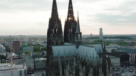 Drone-moves-in-slow-motion-epic-towards-the-Cologne-Cathedral,-it-comes-very-close-to-the-Cologne-Cathedral-and-you-can-see-the-sunbeams-shining-through-the-towers,-cinematic-intro