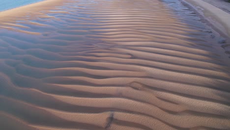 Atemberaubende-Strukturierte-Sandküste-Von-Oben-Mit-Wässrigen-Pools-Und-Blautönen