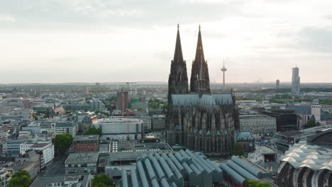 Drone-moves-epic-towards-the-Cologne-Cathedral,-it-comes-very-close-to-the-Cologne-Cathedral-and-you-can-see-the-sunbeams-shining-through-the-towers,-cinematic-intro