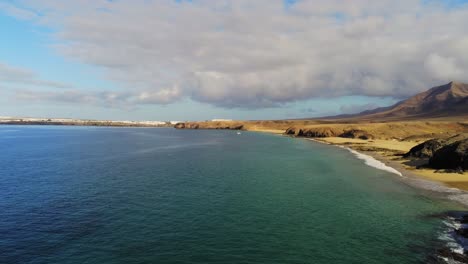 Majestic-mountain-coastline-with-sandy-beaches-in-Lanzarote-island,-aerial-drone-view
