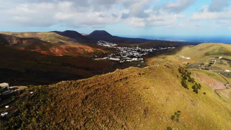 Beautiful-white-town-houses-in-mountain-valley-in-Lanzarote-island,-aerial-drone-view