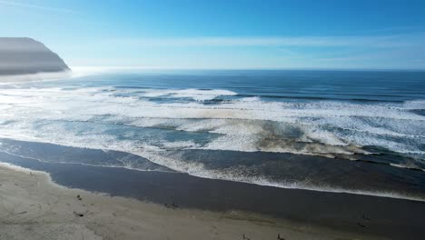 4K-aerial-drone-shot-floating-over-ocean-horizon-at-Seaside,-Oregon-beach
