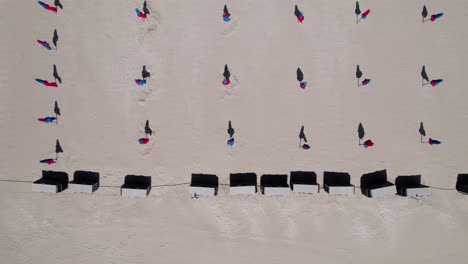 Aerial-top-down,-rows-of-closed-beach-umbrellas-during-summer