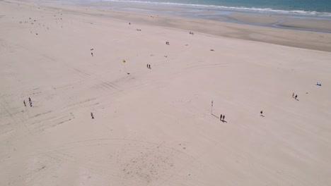 Separated-people-enjoying-sunny-day-on-sandy-beach,-aerial-view
