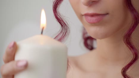 Beautiful-girl-holds-lighted-candle-near-face,-beauty-procedure-preparation