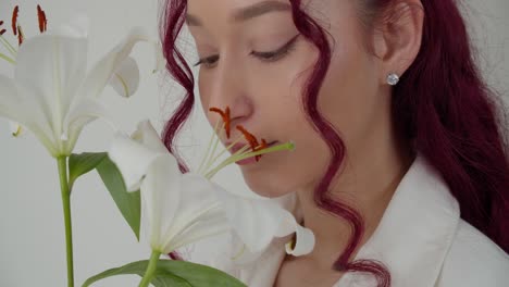 Perfekte-Frau-Mit-Lockigem-Haar-Genießt-Weiße-Lilly-Blume,-Isolierter-Weißer-Hintergrund