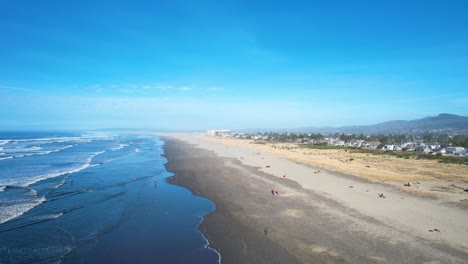 4K-aerial-drone-shot-floating-over-Seaside,-Oregon-beach-on-a-sunny-day