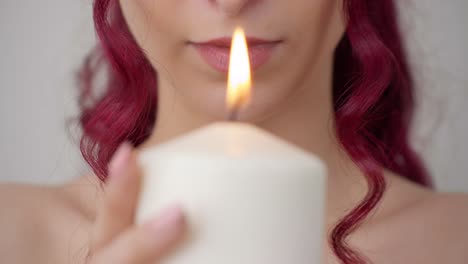 Attraktive-Frau-Mit-Roten-Haaren,-Die-In-Richtung-Kerzenlicht-Blickt,-Nahaufnahme-Von-Vorne