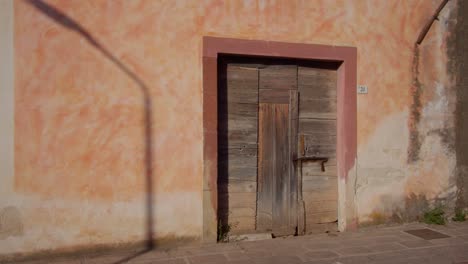 Old-historical-wooden-doors-on-building-wall-in-street-of-Sardinia,-motion-view