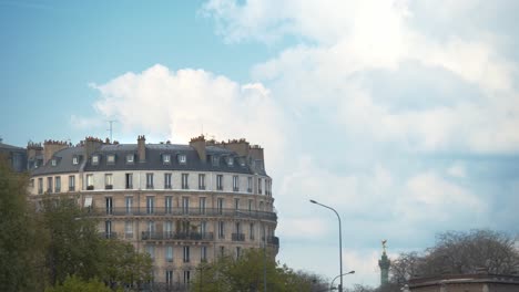 Edificio-De-Apartamentos-De-París-Con-Nubes-Blancas-Esponjosas-Que-Se-Mueven-Lentamente-Detrás,-Vista-Estática
