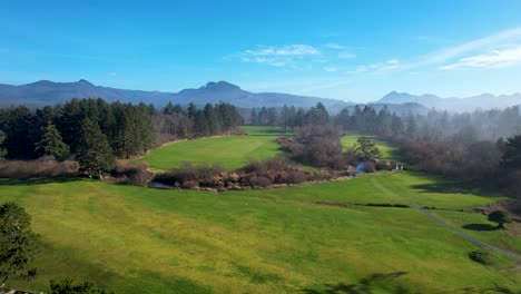 4K-aerial-drone-shot-floating-rising-over-golf-course-at-Seaside,-Oregon-beach-on-a-sunny-day