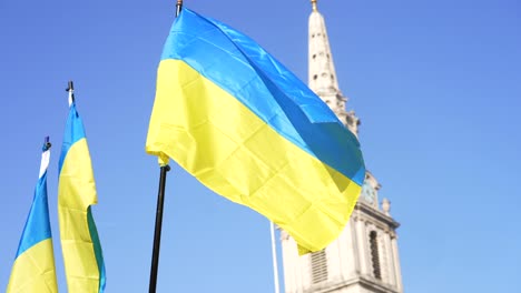 London-stands-with-Ukraine,-Ukrainian-flags-waving-in-Trafalgar-Square-in-London-during-protest-against-war-with-Russia