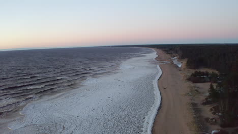 Drone-flight-above-partly-frozen-sea-during-dusk