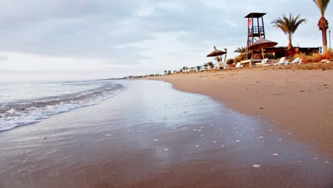 Playa-Tropical-De-Iskele-Con-Sombrillas-Y-Tumbonas-En-La-Costa-De-Chipre,-Vista-En-Movimiento