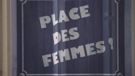 Close-up-gimbal-shot-of-French-sign-saying-womens-place