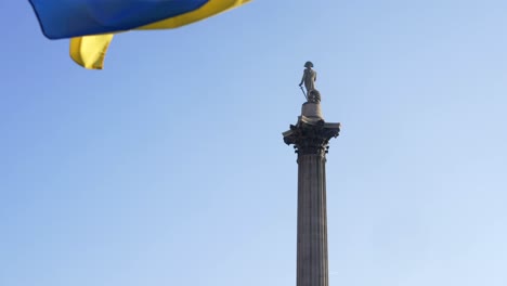 London-stands-with-Ukraine,-Ukrainian-flag-waving-in-Trafalgar-Square-in-London-during-protest-against-war-with-Russia