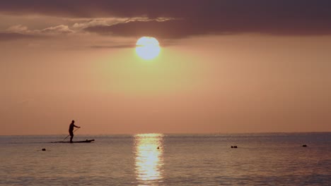 Silhouette-of-lonely-paddler-during-golden-sunset-near-coastline-of-Cyprus