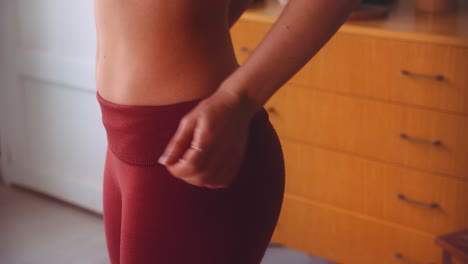 Attraktive-Frau-Mit-Flachem-Bauch,-Die-Rote-Yogahosen-Trägt-Und-Bereit-Für-Das-Training-Ist