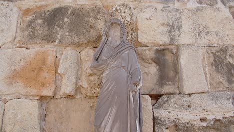 Jesus-statue-near-ancient-historical-limestone-wall-in-Salamis-city,-Cyprus
