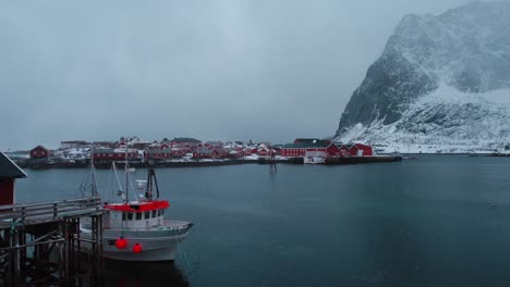 Drone-footage-of-snow-falling-in-the-mountains-of-Reine,-Lofoten-Islands-in-Norway