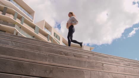 Eine-Frau,-Die-Eine-Joggingübung-über-Die-Holztreppe-Durchführt