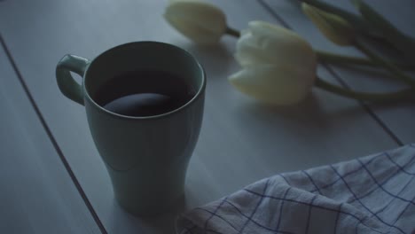 Eine-Tasse-Kaffee-Mit-Weißer-Tulpenblume-Auf-Dem-Tisch