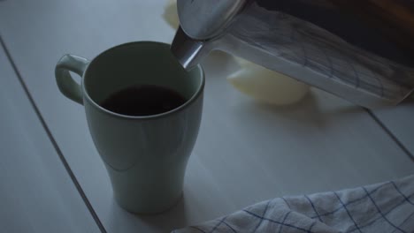 Eine-Halb-Volle-Tasse-Kaffee-Wird-Durch-Einen-Edelstahlkrug-Eingefüllt