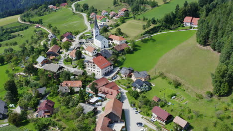 Aufnahme-Einer-Luftaufnahme-über-Einer-Kleinen-Stadt-Mit-Kirche-In-Prevalje-Slowenien