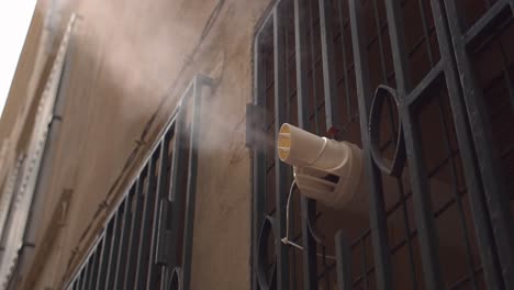 Ventilation-pipe-evaporate-steam-from-inside-building-in-narrow-street,-close-up-view