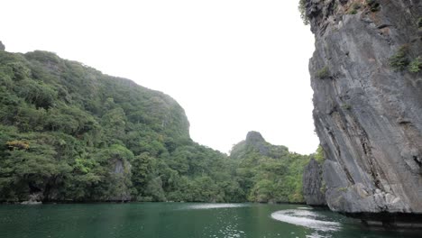Slow-motion-dolly-shot-sailing-in-the-famous-Big-Lagoon-surrounded-by-limestone-cliffs-in-El-Nido,-Palawan,-the-Philippines